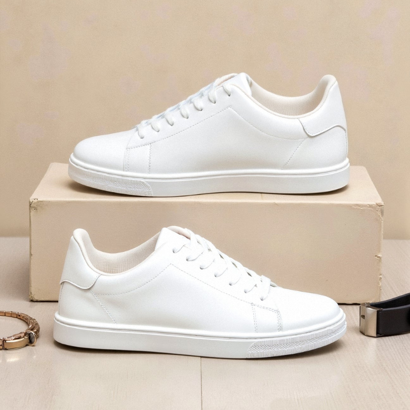 Białe sneakersy męskie ustawione na podwyższeniu, ujęcie estetyczne podkreślające minimalistyczną sylwetkę.