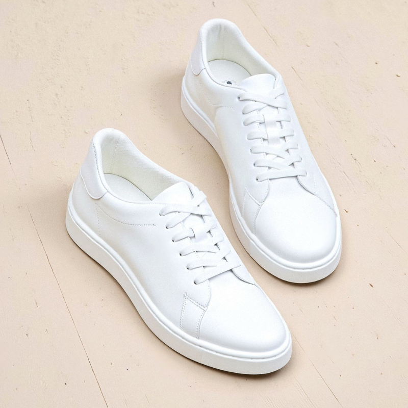 Białe sneakersy męskie ustawione pojedynczo na jasnym tle, estetyczne ujęcie skupione na formie obuwia.