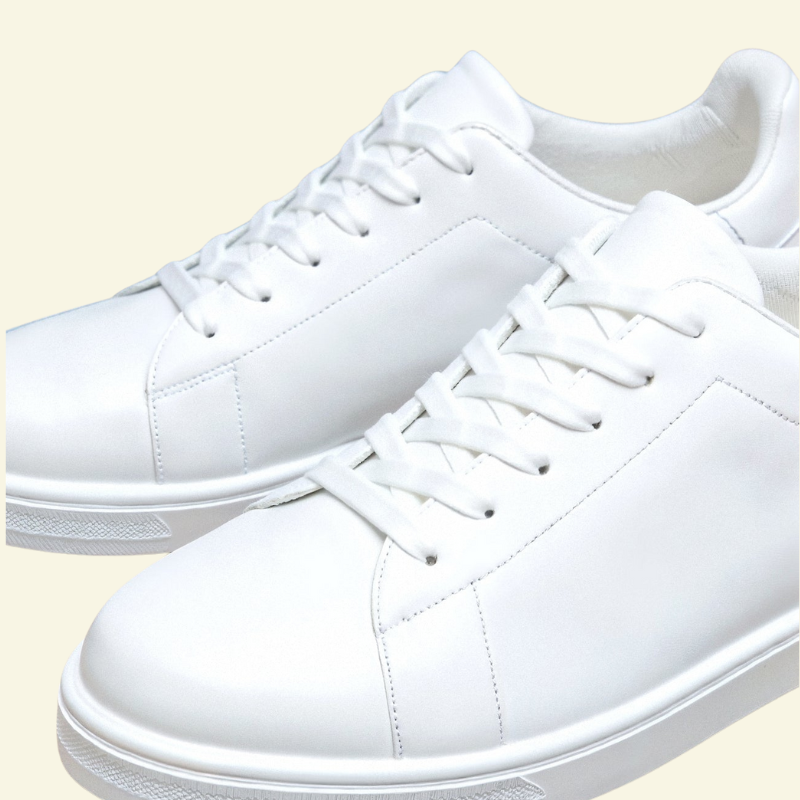 Białe niskie sneakersy męskie w ujęciu z boku, prezentujące jednolitą powierzchnię cholewki i prostą linię podeszwy.