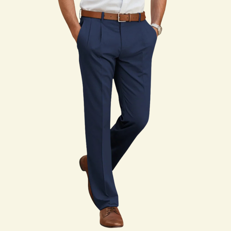 Model w granatowych eleganckich spodniach Slim Fit z zaszewkami, prezentowanych w lekkiej, biznesowej stylizacji.