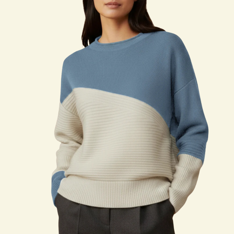 Modelka w jasnoniebieskim swetrze color-block; miękka dzianina, kremowy dół.