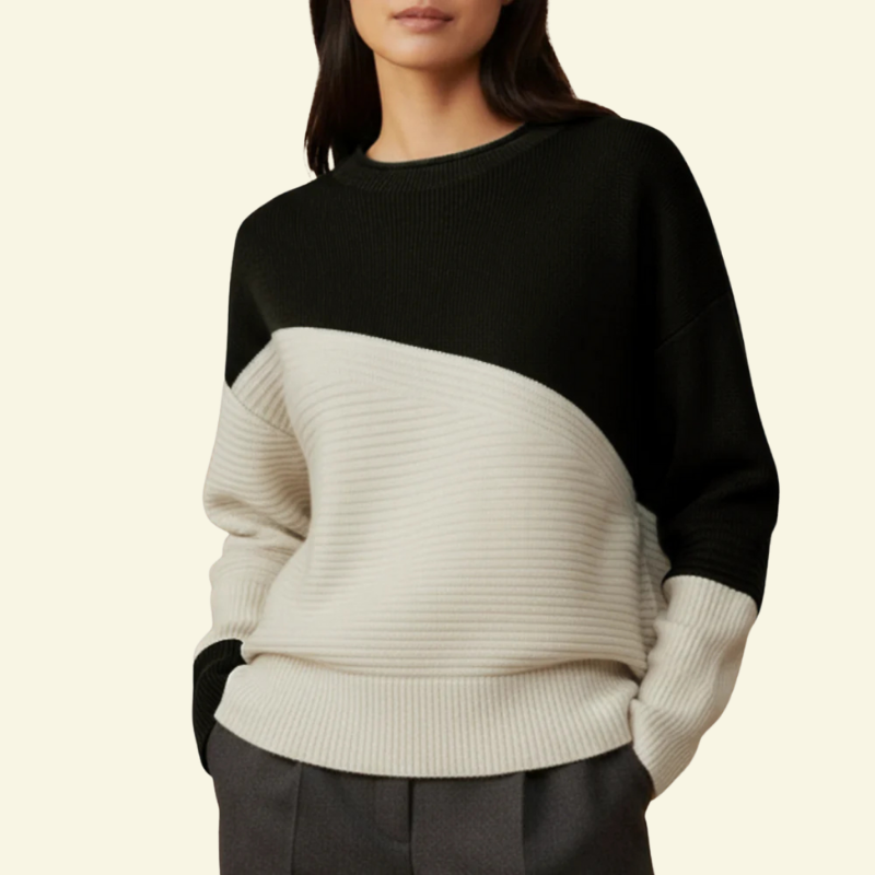 Modelka w czarno-kremowym swetrze color-block; minimalistyczny, wyrazisty kontrast.