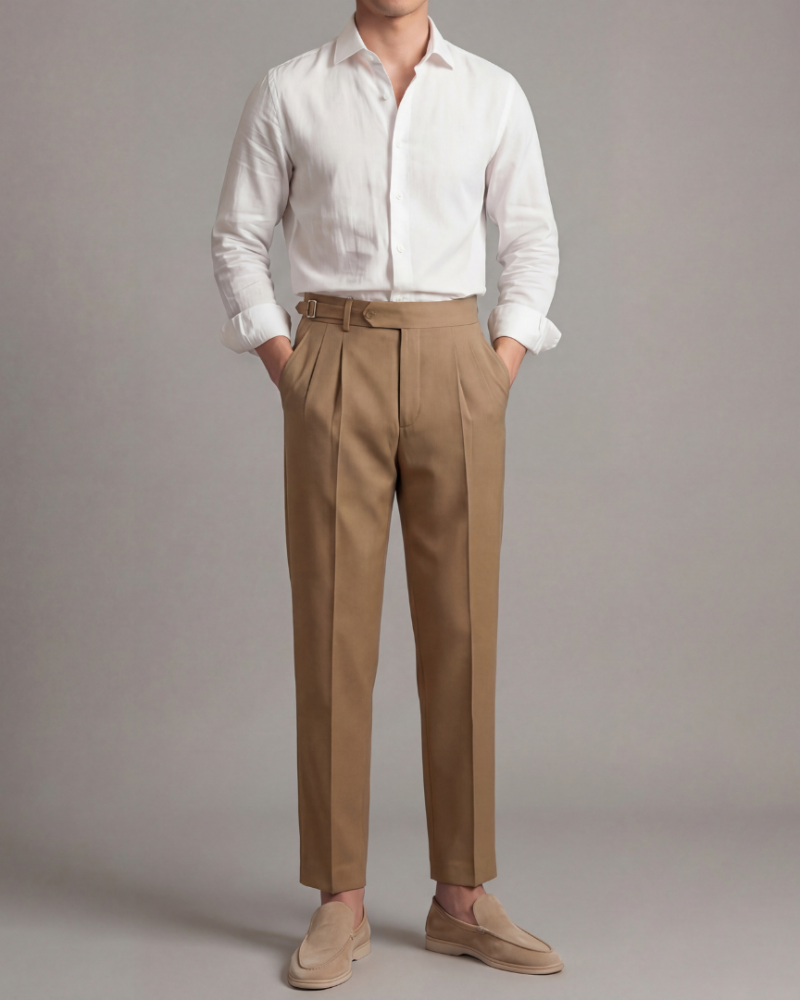 Model mężczyzna w brązowych spodniach garniturowych zakładki styl elegancki
