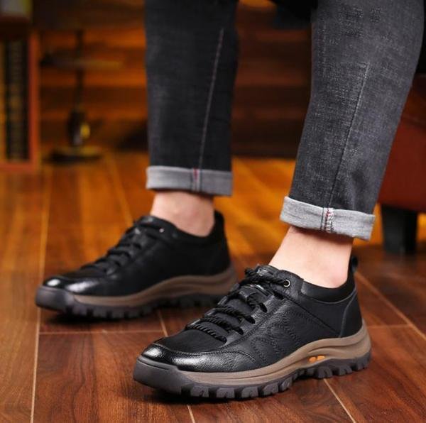 Czarne sneakersy męskie noszone przez modela, ujęcie na stopach w pozycji stojącej, prezentujące masywną podeszwę.